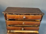 an old wooden box with five drawers on top of it