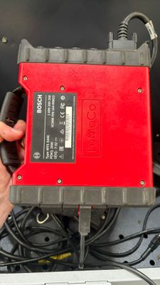 une personne tenant un objet rouge et noir dans la main