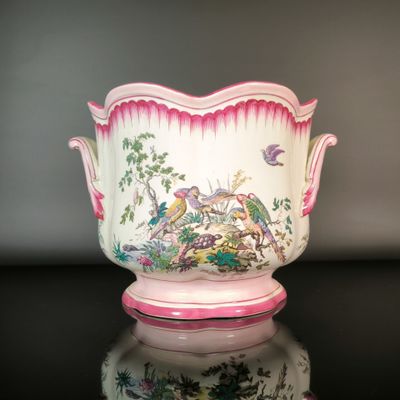 a pink and white vase with a bird design on it