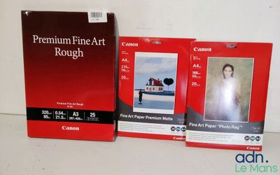 deux boîtes de papier photo « Premium Fine Art » de Canon posées sur une table