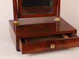 a small wooden vanity with a mirror on top of it
