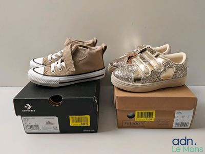une paire de chaussures pour tout-petits dans une boîte posée sur une surface blanche