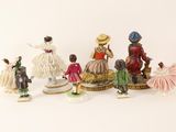 many figurines of different styles and colors on a white surface