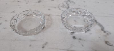 une paire de cendriers en verre transparent posés sur un plan de travail en marbre