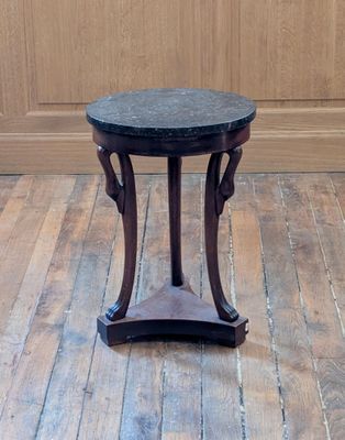 a small table with a marble top on a wooden floor