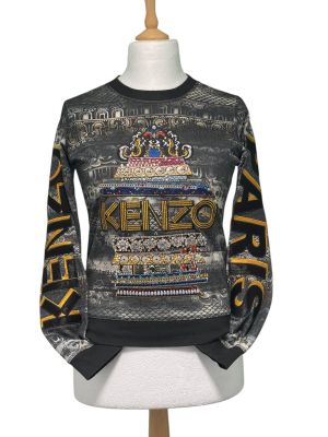 un pull noir orné de lettres dorées et d'une couronne