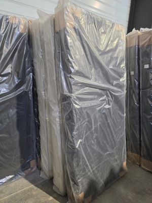 many pieces of furniture wrapped in plastic in a warehouse