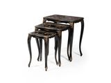 un ensemble de trois tables gigognes noires et dorées sur fond blanc