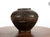 a brown vase sitting on top of a wooden table