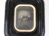 an old photo of a woman and a child in a black frame