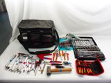 tools laid out on a white table with a bag of tools