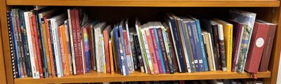 a wooden book shelf with many books on it