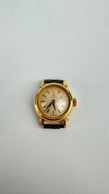une montre en or avec un bracelet noir sur un fond blanc