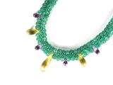 green and purple beaded necklace with gold accents on a white background