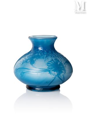 un vase bleu posé sur une surface blanche
