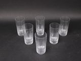 six verres transparents posés les uns à côté des autres sur une table
