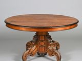 a round table with a wooden top and carved legs