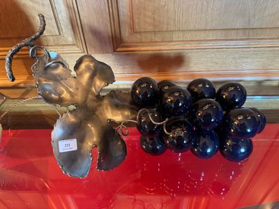 un saladier en verre sur lequel est disposée une grappe de raisin
