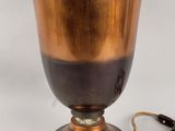 a gold vase with a black handle on a white background