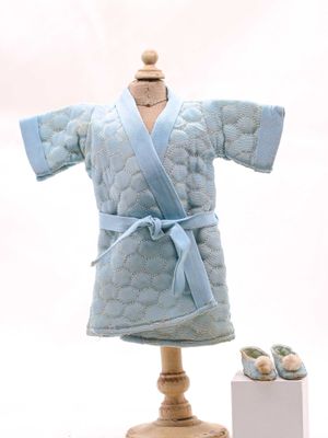 une robe bleue posée sur un support en bois à côté d'un gâteau