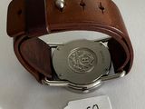 a watch with a brown leather band and a tag on it
