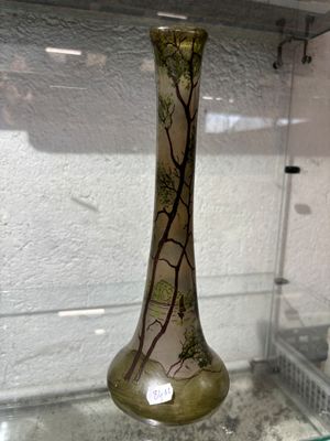 une vitrine en verre sur laquelle est posé un vase en verre