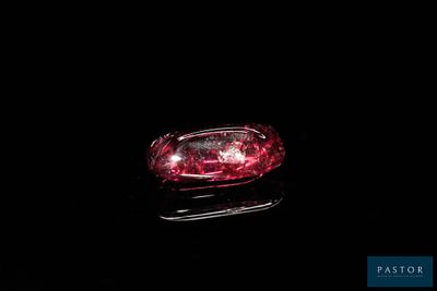 an image of a close up of a red diamond on a black surface