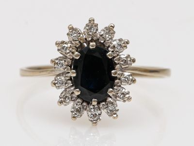 un gros plan d'une bague sertie d'un diamant noir et blanc sur une surface blanche