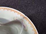 a white plate with a gold rim and a spoon