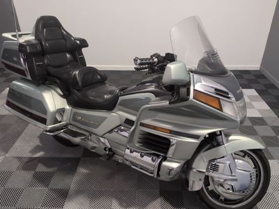 une moto argentée et noire garée sur un sol à damier