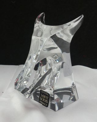 une sculpture en verre transparent représentant un cheval, posée sur une table