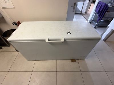 a small white chest freezer sitting on a tiled floor
