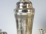 three silver vases sitting next to each other on a white surface