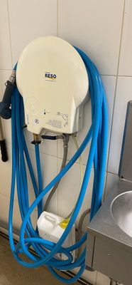 un tuyau bleu fixé au mur à côté d'un évier