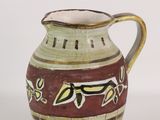 a brown and green vase with a flower design on it