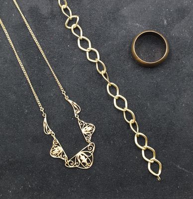 a close up of a necklace and a ring on a table
