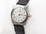 a close up of a wrist watch on a white pillow