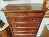 a wooden chest of drawers in a room with a mirror