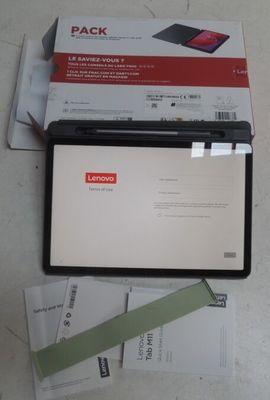 un ordinateur portable posé sur une table, à côté d'un colis