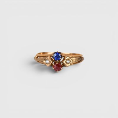a close up of a gold ring with a blue and red stone