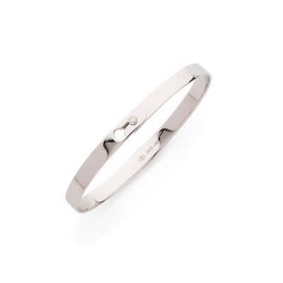 un gros plan sur une boucle d'oreille en argent sertie d'un diamant