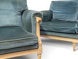 pair of blue velvet upholstered chairs with wood legs and arms