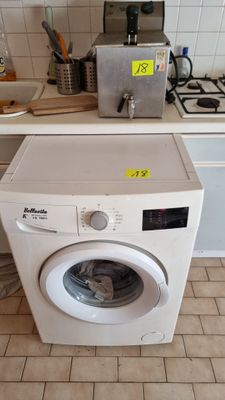 a washing machine sitting in a kitchen next to a stove
