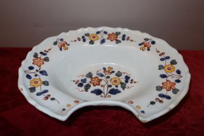 une assiette blanche décorée de fleurs posée sur une table rouge