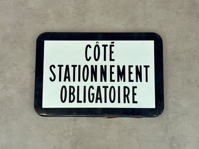 un panneau en noir et blanc sur lequel on peut lire « Cote Station Nement Obligatre »