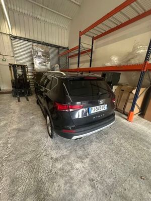 La voiture est garée dans le garage de l'entrepôt.