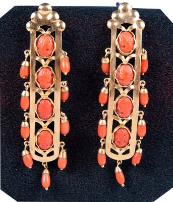 une photo d'une paire de boucles d'oreilles ornées de perles de corail