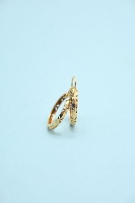 two gold rings on a white surface with a light blue background