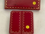 two red boxes with gold designs on them sitting on a white surface