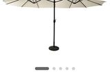un parapluie blanc posé sur une table près d'un mur blanc